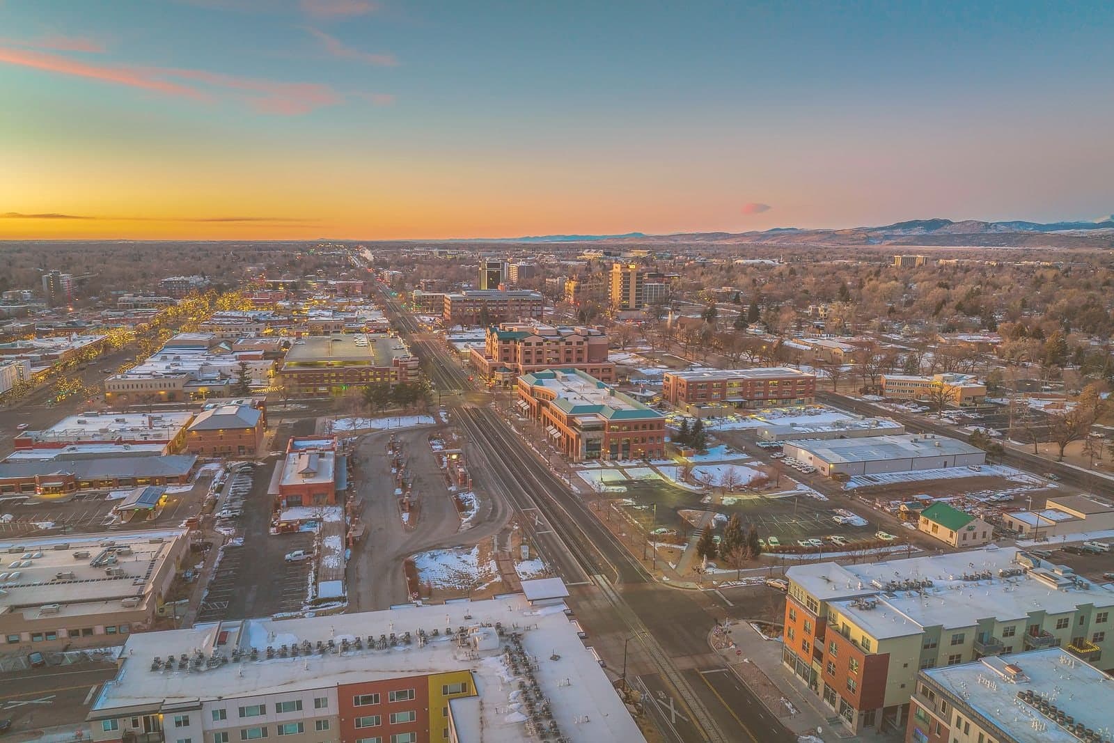 A northern Colorado town from the air at sunrise, the foothills along the horizon.